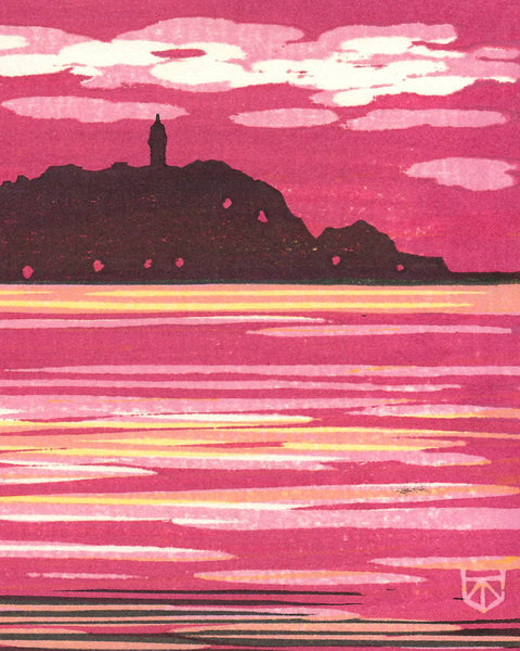 Handmade woodblock print depicting a silhouette of an island with a lighthouse against a pink sky.