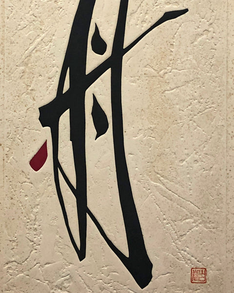 Black calligraphy on textured beige paper with a red stamp against a gray background