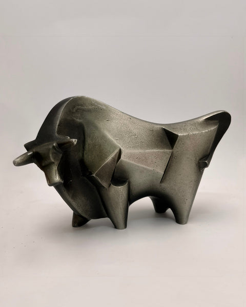 A modern abstract bull sculpture made of textured gray metal, shown on a neutral light gray background.