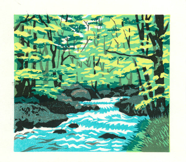 Handmade woodblock print of a forest stream with green trees and rocks.