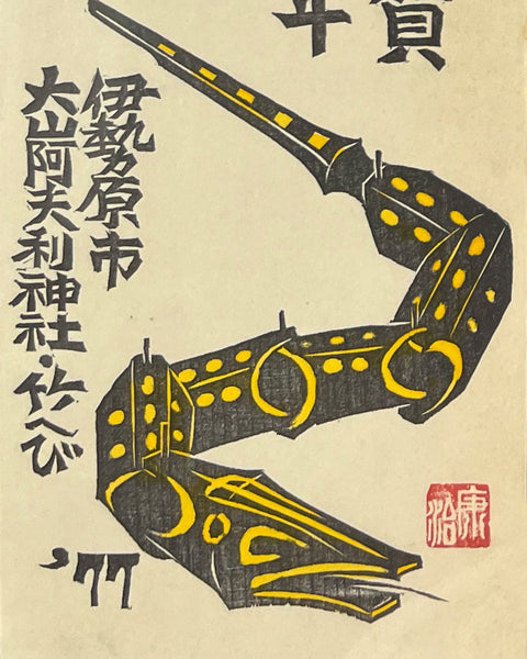 Decorative item with yellow snake and Japanese calligraphy on a beige background