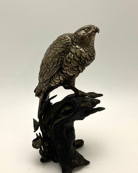 Antique Japanese bronze sculpture of a silvered falcon perched on a weathered tree stump decorated with plum blossoms.