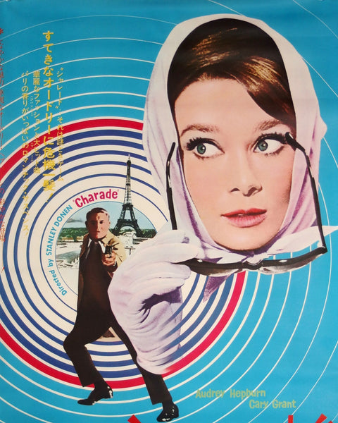 Movie poster for 'Charade' featuring a woman with a headscarf and a man with a gun, set against a blue background with concentric circles.